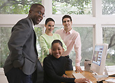 Team gathered around a computer in a bright office